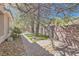 Charming side yard with a stone pathway, mature trees, and artificial turf, offering a serene and low-maintenance space at 537 Tuscany View St, Las Vegas, NV 89145