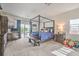 Spacious main bedroom featuring a four-poster bed, patio access, and neutral decor at 5755 E La Campana Dr, Pahrump, NV 89061