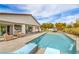 Backyard pool with waterfall feature, covered patio, lounge furniture, and desert landscaping for outdoor enjoyment at 5755 E La Campana Dr, Pahrump, NV 89061