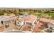 A home features a tile roof, mature trees, and a beautifully landscaped yard near a serene pond at 5755 E La Campana Dr, Pahrump, NV 89061
