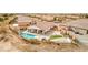 Beautiful aerial view showcases backyard swimming pool, covered patio, artificial turf, and desert landscape at 5755 E La Campana Dr, Pahrump, NV 89061