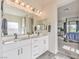 Bright bathroom showcasing a double vanity with modern fixtures and a view of the bedroom at 5755 E La Campana Dr, Pahrump, NV 89061