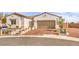 Charming single-story home featuring a brick driveway, stone accents, and a two-car garage at 5755 E La Campana Dr, Pahrump, NV 89061