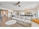 Bright, open-concept living room with a plush white sofa, modern lighting, and wood flooring at 5755 E La Campana Dr, Pahrump, NV 89061