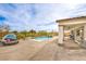 Backyard features a sparkling pool, lounge seating, and covered patio, ideal for outdoor living at 5755 E La Campana Dr, Pahrump, NV 89061