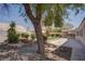 This home features a well-manicured backyard with a lush lawn, mature landscaping, and a charming patio area at 6032 Port Of Dreams Dr, Las Vegas, NV 89130