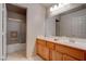Bathroom with a double sink, a shower with glass doors, and a wooden vanity with storage space at 6032 Port Of Dreams Dr, Las Vegas, NV 89130