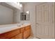 Bathroom featuring wooden vanity, spacious countertop with double mirrors, and a door to the water closet at 6032 Port Of Dreams Dr, Las Vegas, NV 89130
