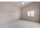 A sunlit bedroom with neutral walls, plush carpet, a ceiling fan, and a shuttered window at 6032 Port Of Dreams Dr, Las Vegas, NV 89130