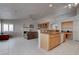 Open kitchen features granite counters, island with bar seating, and a seamless connection to the living room and fireplace at 6032 Port Of Dreams Dr, Las Vegas, NV 89130