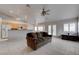 Living room featuring tile floors with kitchen view, ceiling fans, and natural lighting at 6032 Port Of Dreams Dr, Las Vegas, NV 89130