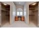 Walk-in closet featuring built-in shelves, tile floors, and natural lighting at 6032 Port Of Dreams Dr, Las Vegas, NV 89130