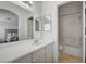 Bright bathroom with a white vanity, a large mirror and a shower over bath tub at 6404 Extreme Shear Ave # 103, Henderson, NV 89011