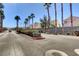 Gated community entrance with lush landscaping and rows of palm trees providing shade and elegance at 6404 Extreme Shear Ave # 103, Henderson, NV 89011