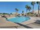Community pool with clear blue water, palm trees, and plenty of lounge chairs for relaxation and enjoyment at 6404 Extreme Shear Ave # 103, Henderson, NV 89011
