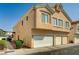Beige two-story home with a three-car garage and well-kept landscaping at 6404 Extreme Shear Ave # 103, Henderson, NV 89011