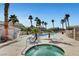 Community hot tub and pool area surrounded by palm trees and lounge chairs for a relaxing oasis at 6404 Extreme Shear Ave # 103, Henderson, NV 89011