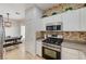 Kitchen featuring stainless steel oven, white cabinets and decorative backsplash at 6404 Extreme Shear Ave # 103, Henderson, NV 89011