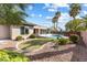Inviting backyard oasis with a sparkling pool, lush greenery, and a charming patio area at 6895 Kelp Ledge Ct, Las Vegas, NV 89131