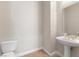 Powder room featuring a pedestal sink, toilet, and neutral wall color at 6895 Kelp Ledge Ct, Las Vegas, NV 89131