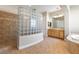 Bathroom with a glass block shower wall, vanity, and soaking tub at 6895 Kelp Ledge Ct, Las Vegas, NV 89131