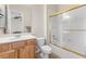 Bathroom featuring a wood vanity, toilet, white walls and shower with gold trim at 6895 Kelp Ledge Ct, Las Vegas, NV 89131