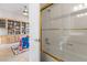 Bathroom featuring glass door shower with gold trim and a view of the playroom with built-in shelving at 6895 Kelp Ledge Ct, Las Vegas, NV 89131