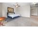 Spacious bedroom featuring a ceiling fan, accent wall art, and a comfortable bed with stylish rug at 6895 Kelp Ledge Ct, Las Vegas, NV 89131