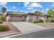 Beautiful single-story home with a well-manicured lawn, stone accents, and a three-car garage at 6895 Kelp Ledge Ct, Las Vegas, NV 89131