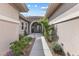 Charming home entrance featuring a walkway, decorative plants, and an arched doorway at 6895 Kelp Ledge Ct, Las Vegas, NV 89131