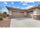 Spacious three-car garage with stone accents and a wide driveway offering ample parking at 6895 Kelp Ledge Ct, Las Vegas, NV 89131