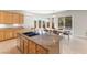 Bright, open kitchen with custom wood cabinets, granite countertops, island with breakfast bar, and pool views at 6895 Kelp Ledge Ct, Las Vegas, NV 89131