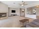 Cozy living room with fireplace, ceiling fan, and view of foyer and kitchen at 6895 Kelp Ledge Ct, Las Vegas, NV 89131