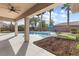 Covered patio overlooking a private pool and landscaped backyard with mature palm trees at 6895 Kelp Ledge Ct, Las Vegas, NV 89131