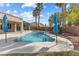 Backyard pool and patio featuring desert landscaping and lounge umbrellas on a sunny day at 6895 Kelp Ledge Ct, Las Vegas, NV 89131