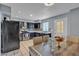 Eat-in kitchen with dark cabinets, stainless appliances, tile flooring, and dining room set at 7030 Burcot Ave # D106, Las Vegas, NV 89156