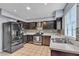Well-lit kitchen with dark wood cabinets, mosaic backsplash, stainless appliances and tile flooring at 7030 Burcot Ave # D106, Las Vegas, NV 89156
