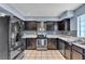 Kitchen features stainless steel appliances, dark cabinets, tile flooring and ample countertop space at 7030 Burcot Ave # D106, Las Vegas, NV 89156