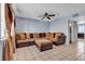 A comfy living room is staged with a ceiling fan and large sofa covered with pillows at 7030 Burcot Ave # D106, Las Vegas, NV 89156