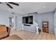 A living room with a large TV, decorative stairs, and beige tile flooring at 7030 Burcot Ave # D106, Las Vegas, NV 89156