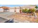 A well-kept single-story home with a three car garage, desert landscaping, and decorative cacti accents at 7033 Red Tide Dr, Las Vegas, NV 89131