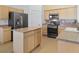 Functional kitchen featuring natural wood cabinets, stainless steel appliances and a granite countertop island at 7033 Red Tide Dr, Las Vegas, NV 89131
