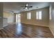 Spacious living room with wood-look flooring, ceiling fans, and slider doors at 7322 Fools Gold St # 102, Las Vegas, NV 89149