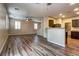 Open-concept living space with kitchen view and wood-look floors at 7322 Fools Gold St # 102, Las Vegas, NV 89149