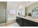 Bathroom featuring double sinks, framed mirror, shower and tub with window at 7900 Eastern Elk St, Las Vegas, NV 89149