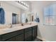 Bathroom with double sinks, dark cabinets, neutral countertop, and great natural light at 7900 Eastern Elk St, Las Vegas, NV 89149