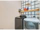 Modern laundry room with a front loading washer and dryer and a storage shelf at 7900 Eastern Elk St, Las Vegas, NV 89149