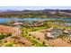 Panoramic aerial view of a beautiful community with a golf course, lake, and stunning mountain backdrop at 8 Reflection Cove Dr, Henderson, NV 89011