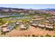 Wide aerial view of a desert community, highlighting the golf course, lake and residential homes at 8 Reflection Cove Dr, Henderson, NV 89011