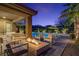 Inviting backyard patio area with a fire pit, pool and lush landscaping at 8 Reflection Cove Dr, Henderson, NV 89011